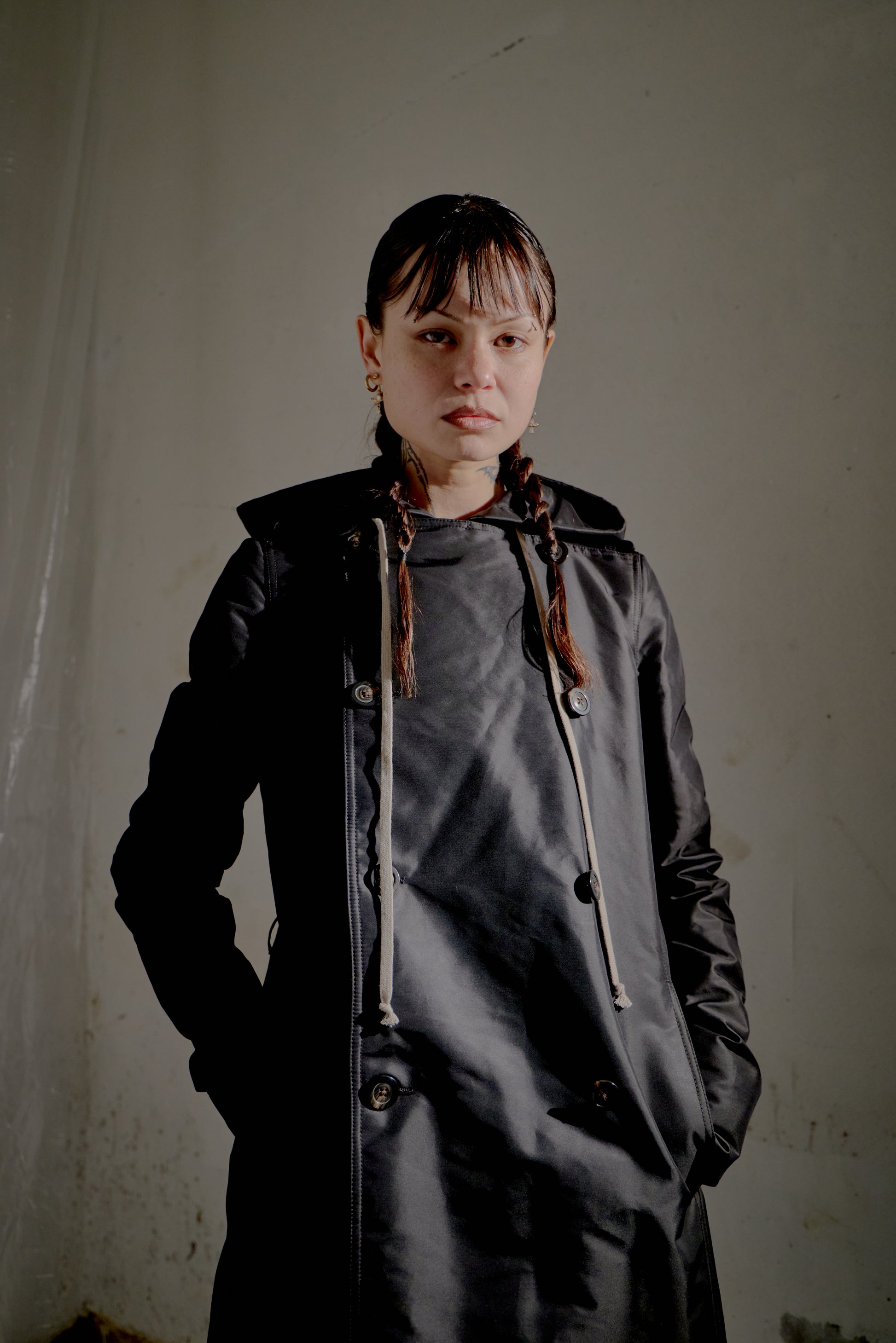 Person wearing a dark Rick Owens coat against a plain background