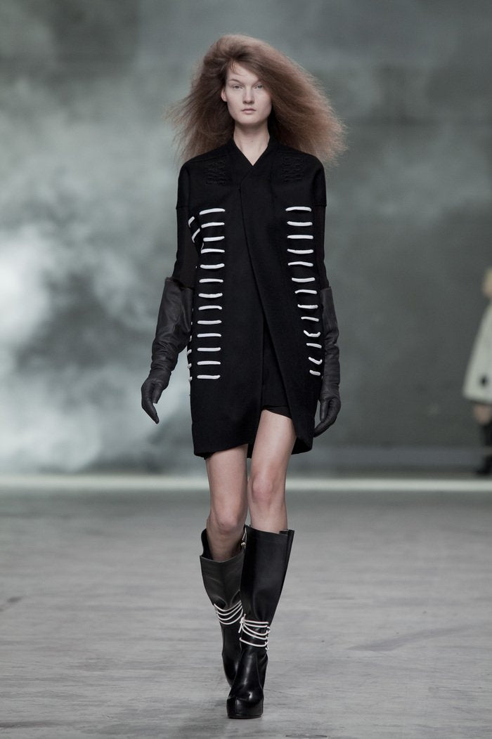 Black leather knee-high Rick Owens boot on a wooden surface