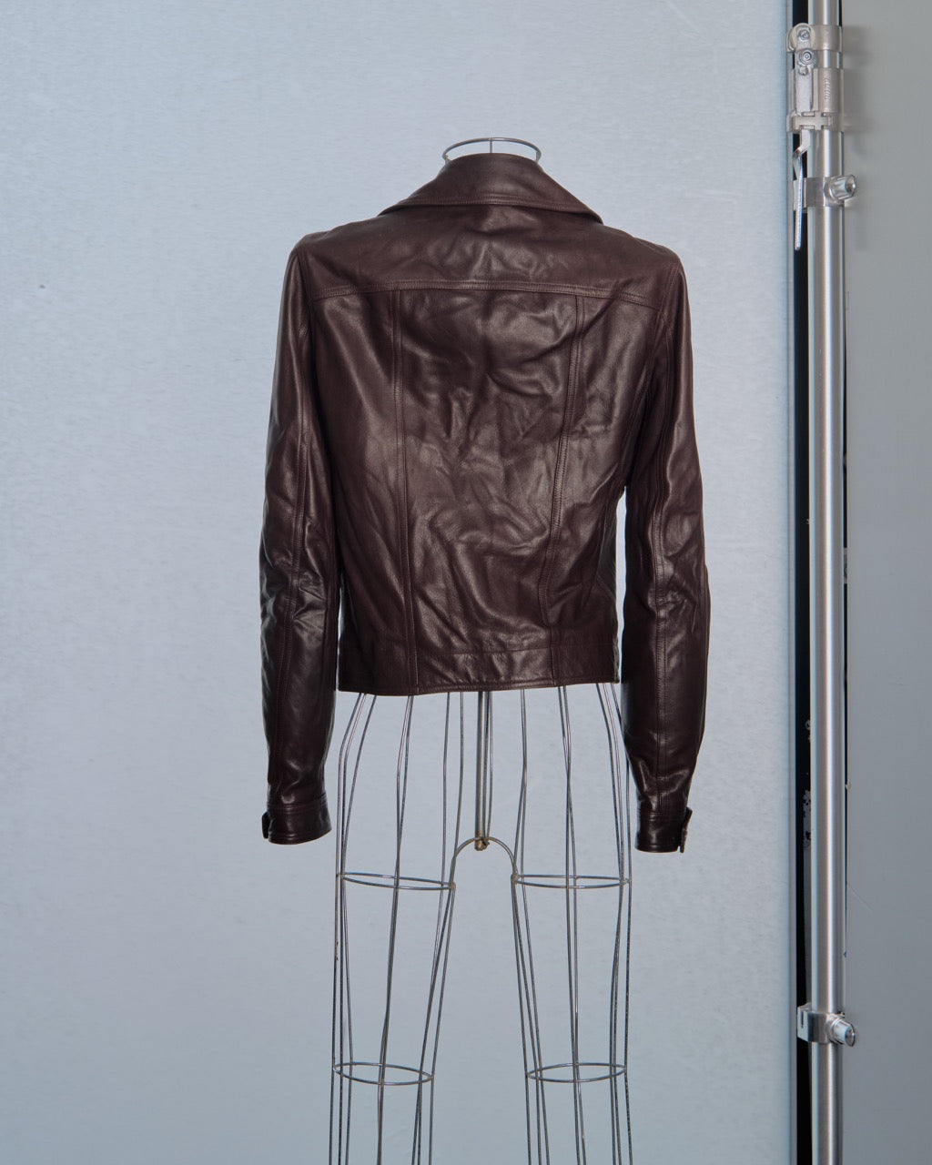 Brown leather Rick Owens jacket on a mannequin against a light blue background