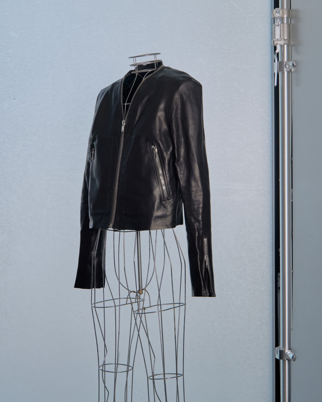 Black leather Rick Owens jacket on a mannequin against a light gray background
