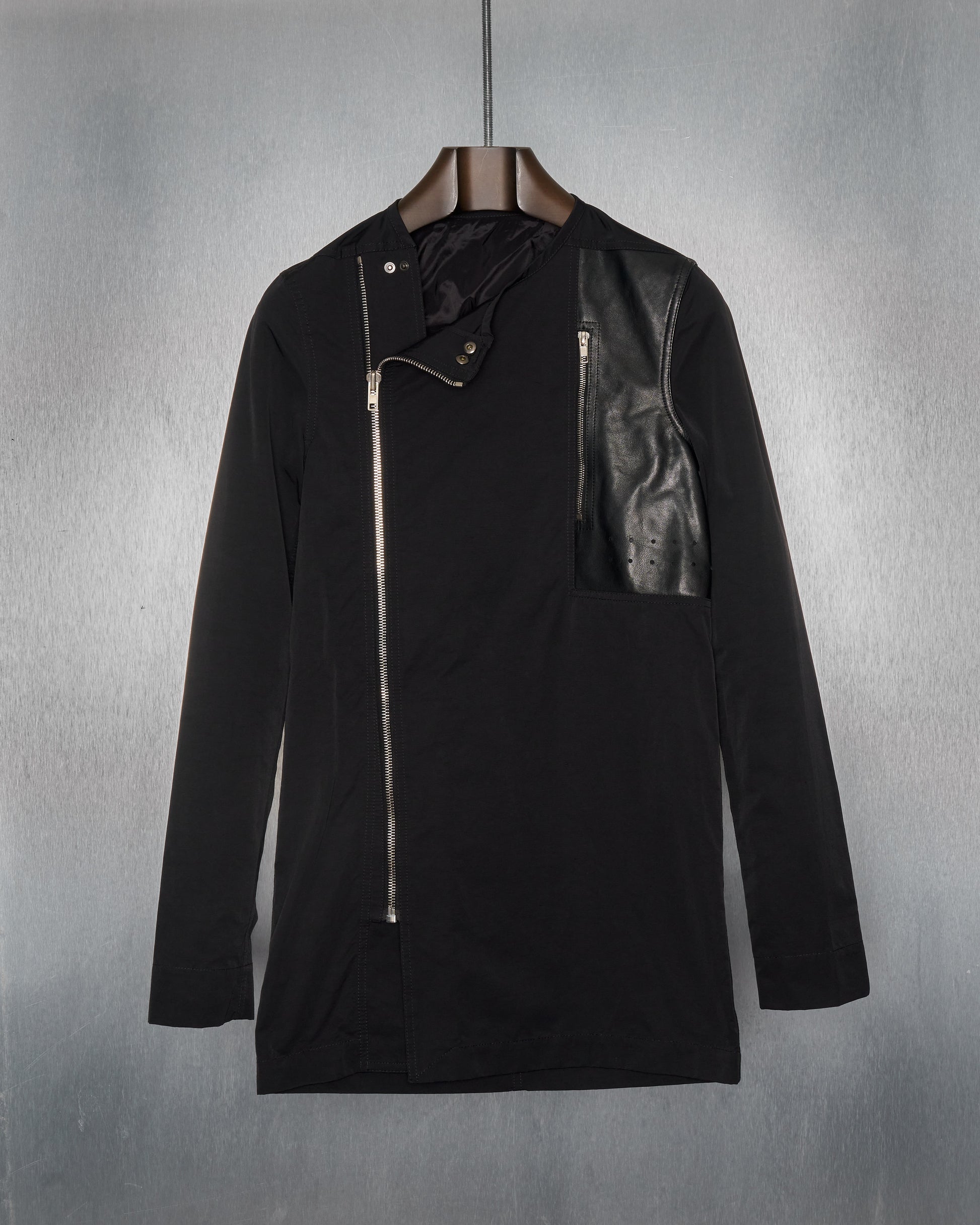 A black Rick Owens zip-up collarless coat with an asymmetric front zip and a perforated breast pocket made from soft grained calfskin.