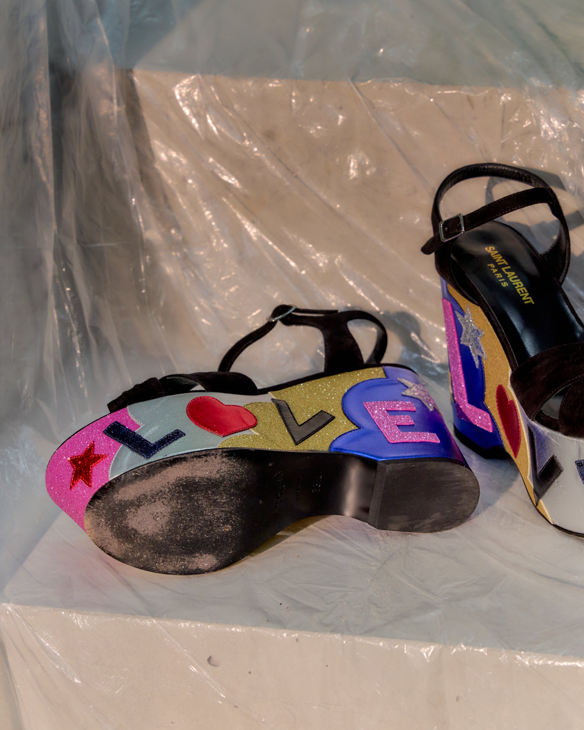 Colourful Saint Laurent sandals with 'LOVE' design on a white surface