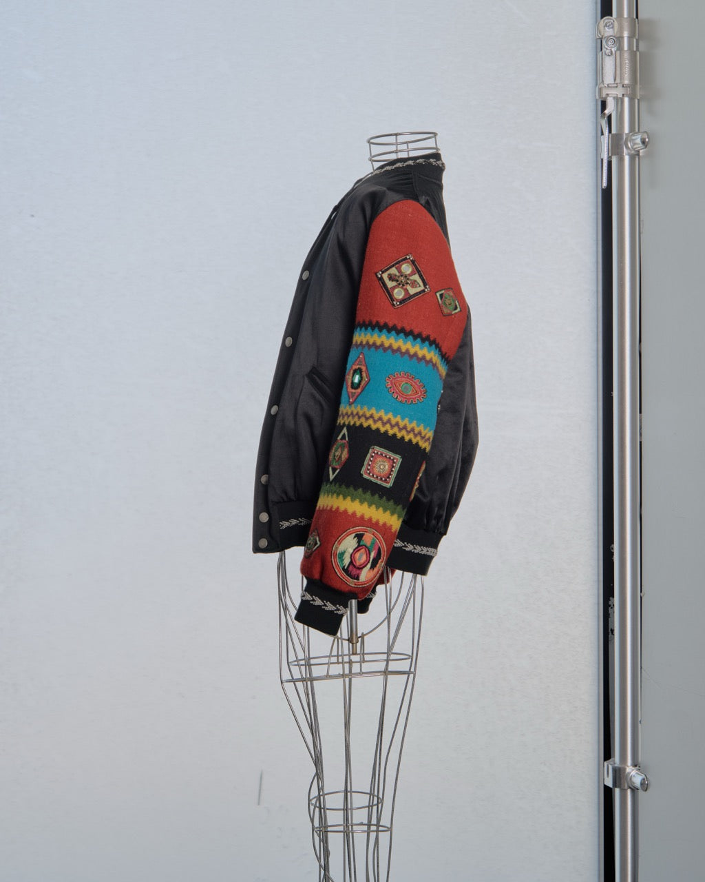 Colourful Saint Laurent jacket with patterns on a mannequin against a plain background
