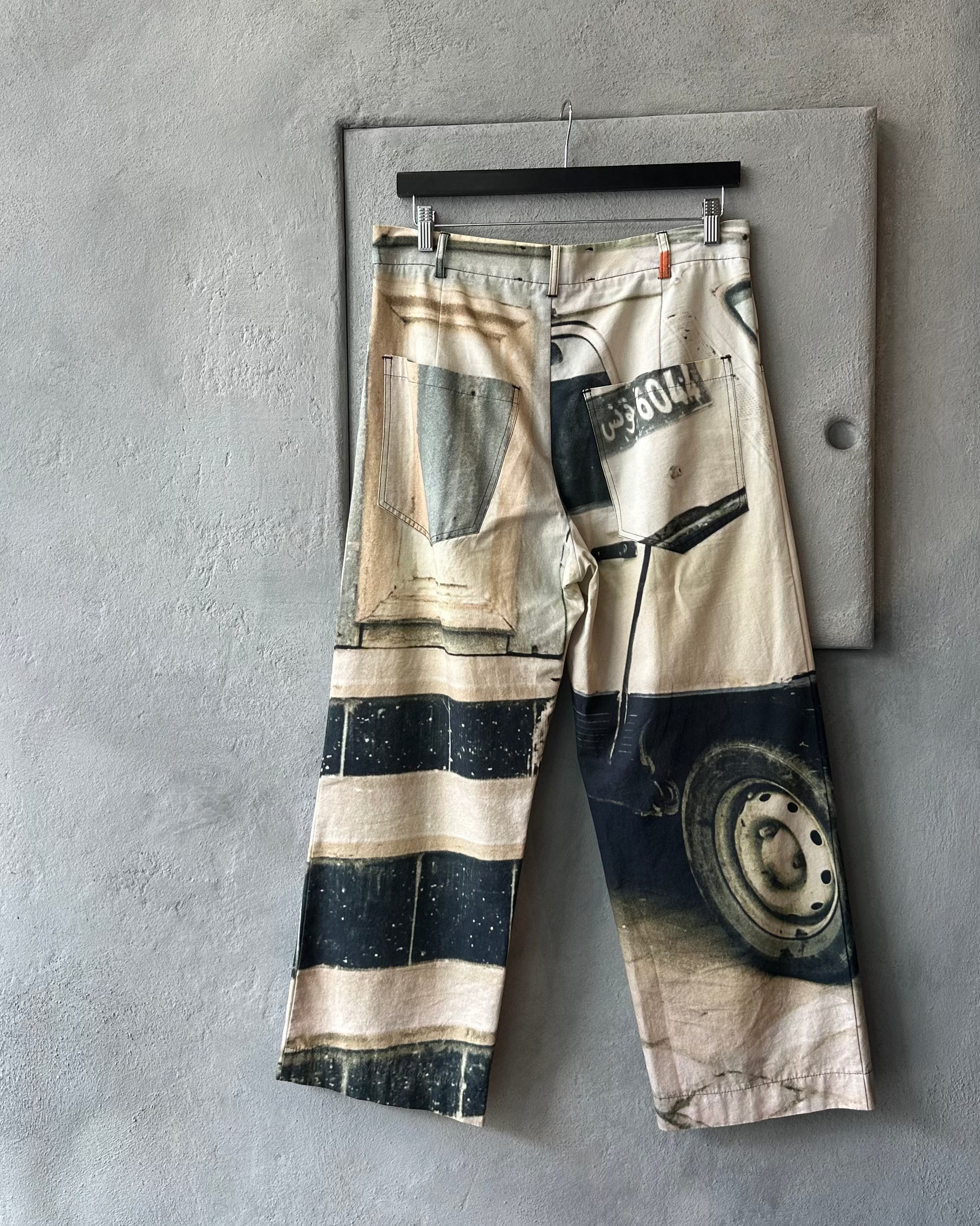 Song For The Mute pants with graphic design on a gray surface