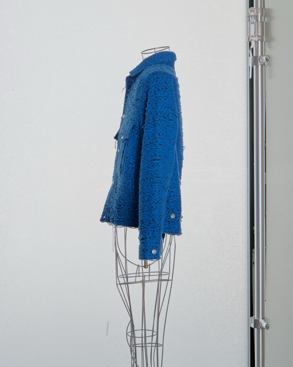 Blue textured Song For The Mute coat on a mannequin against a white background