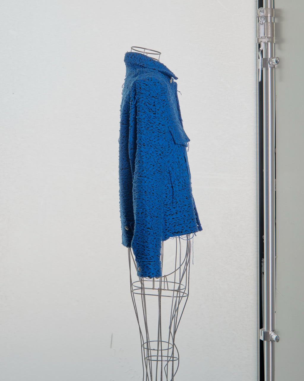 Blue textured Song For The Mute coat on a mannequin against a white background