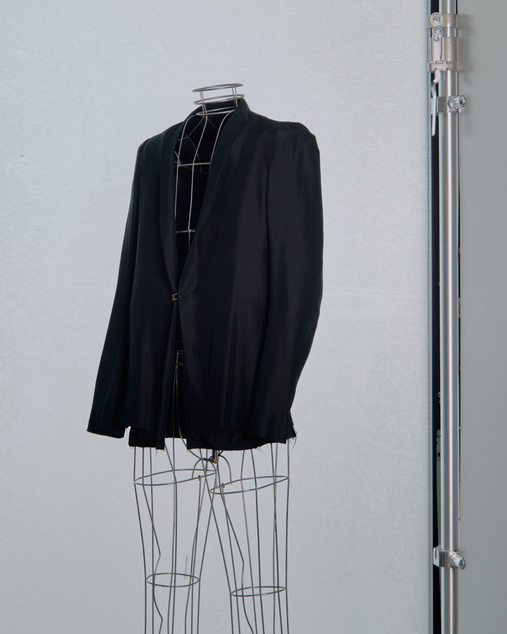 Black Song For The Mute blazer on a wire mannequin against a light gray background