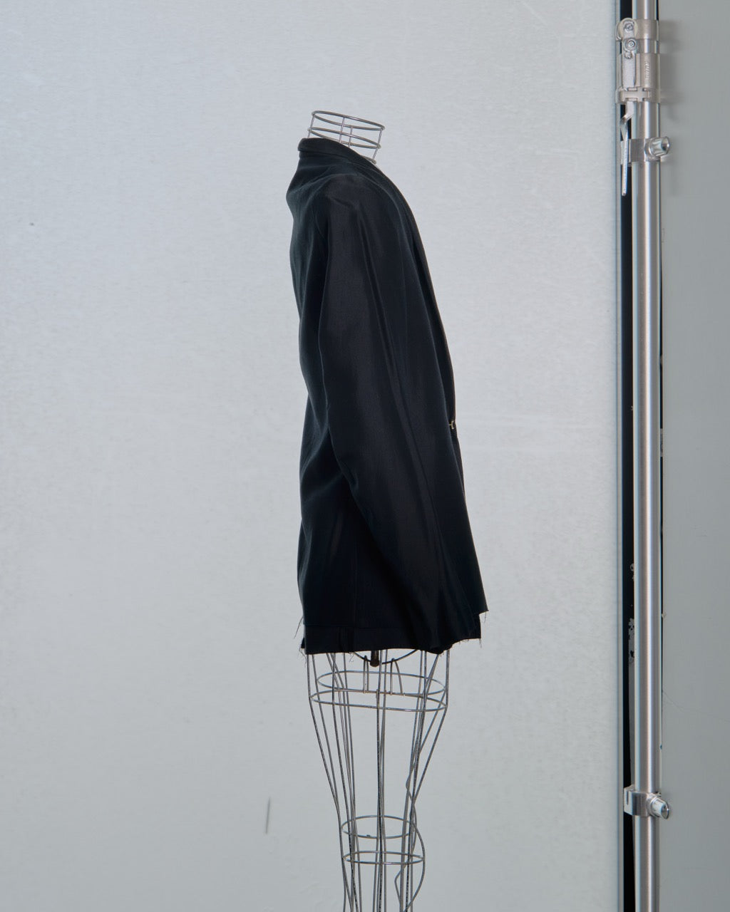Black Song For The Mute jacket on a wire mannequin against a white wall