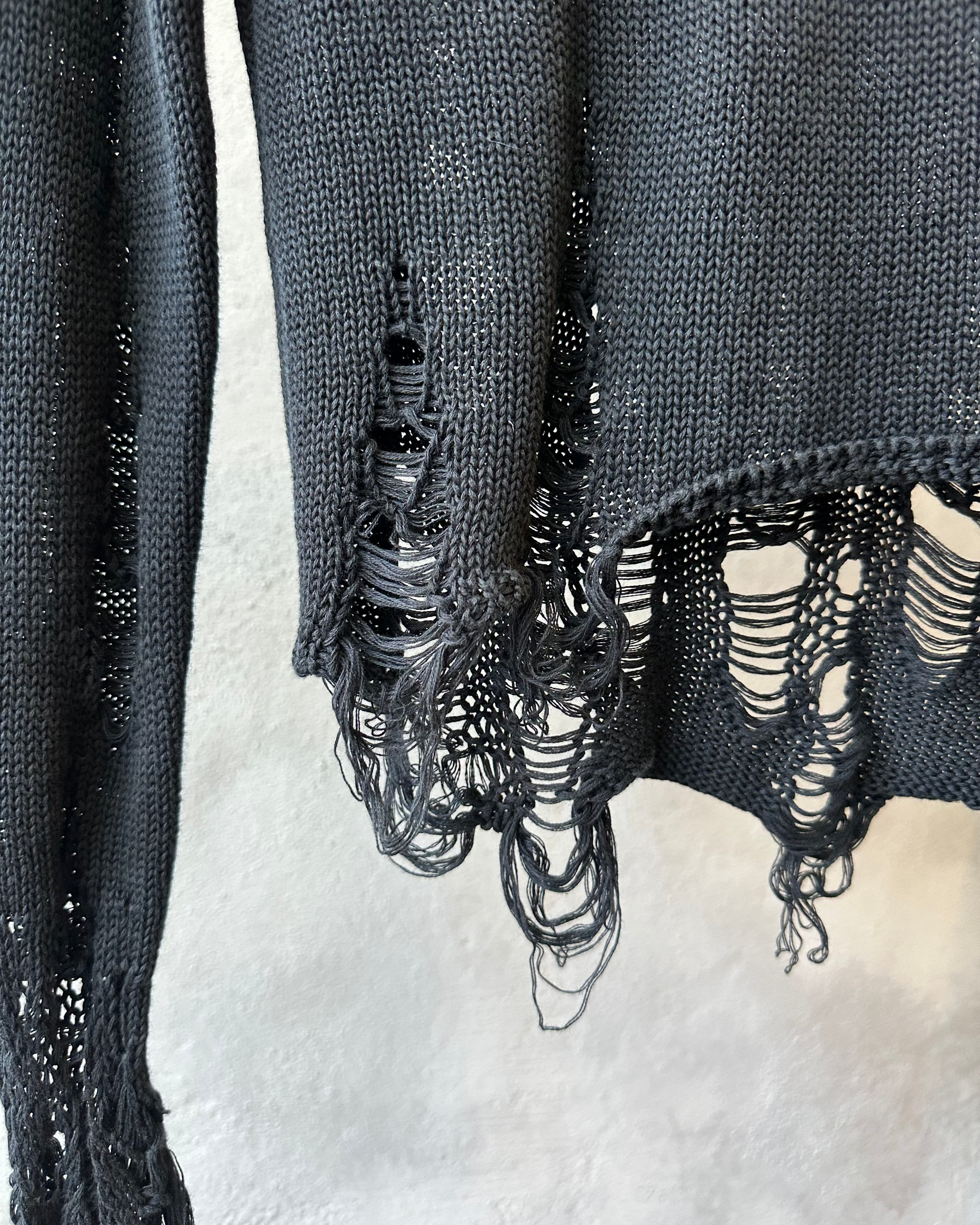 Black knit sweater Song For The Mute with distressed details on a white background