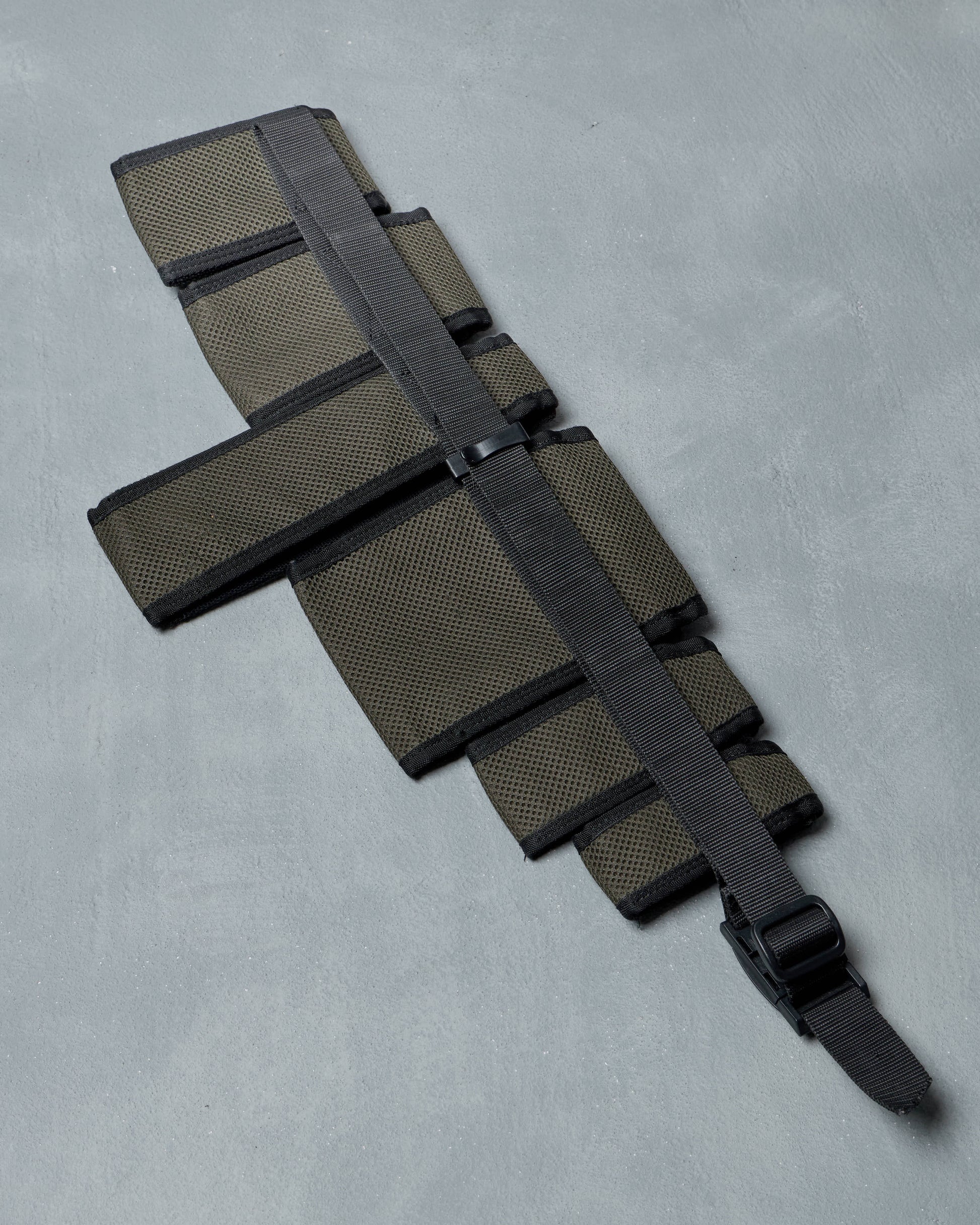 Black and gray tactical belt bag from Undercover on a light gray background