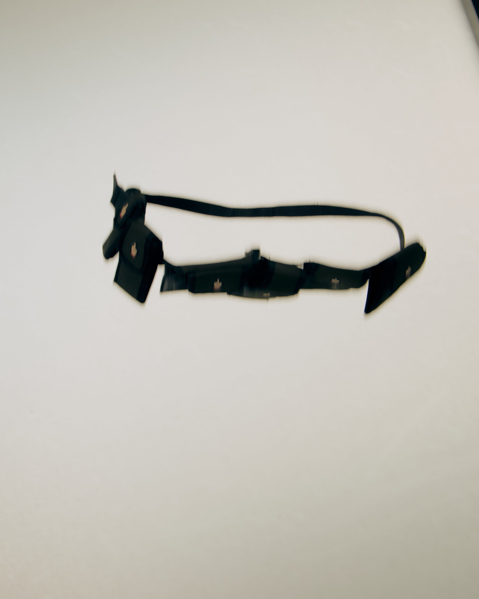 Black Undercover belt bag with decorative elements on a white background
