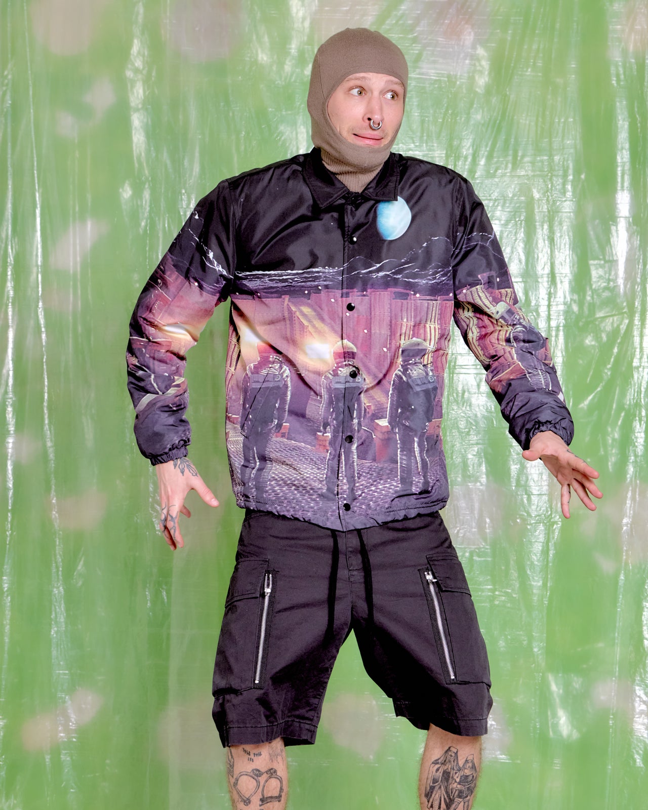 Person wearing an Undercover x 2001: A Space Odyssey jacket with a graphic design on a green textured background