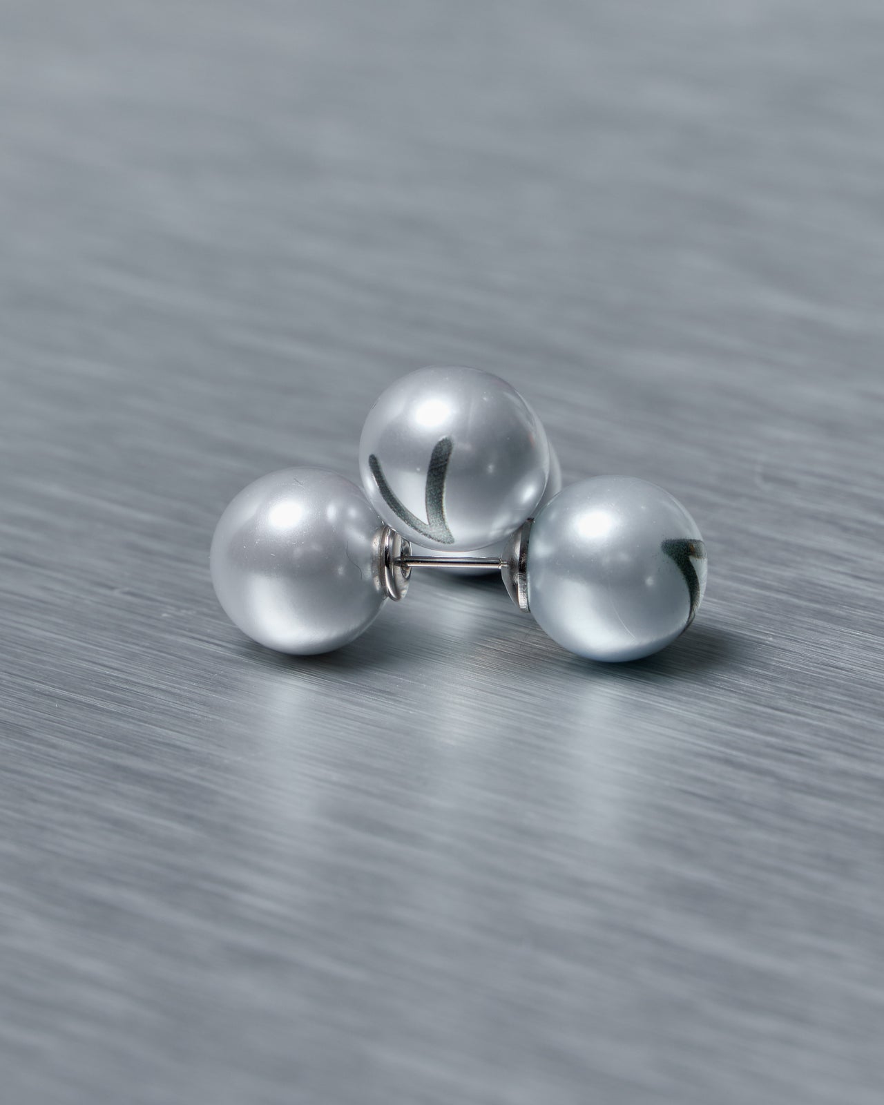 Set of baby blue Vetements earrings on a textured gray surface