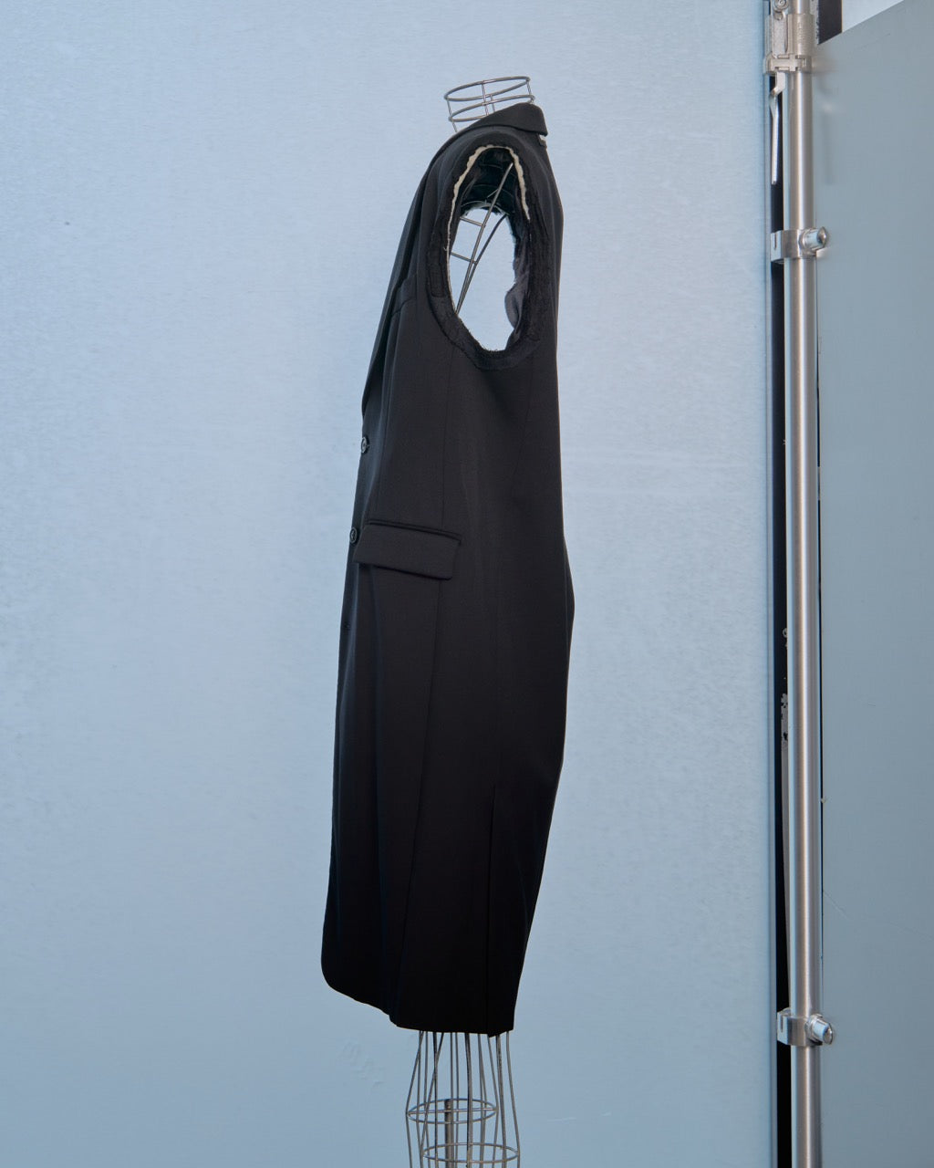 Black sleeveless Vetements dress on a mannequin against a light blue wall.