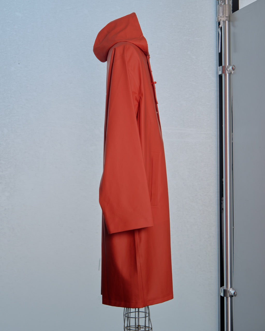 Red Vetements coat on a mannequin against a light gray wall