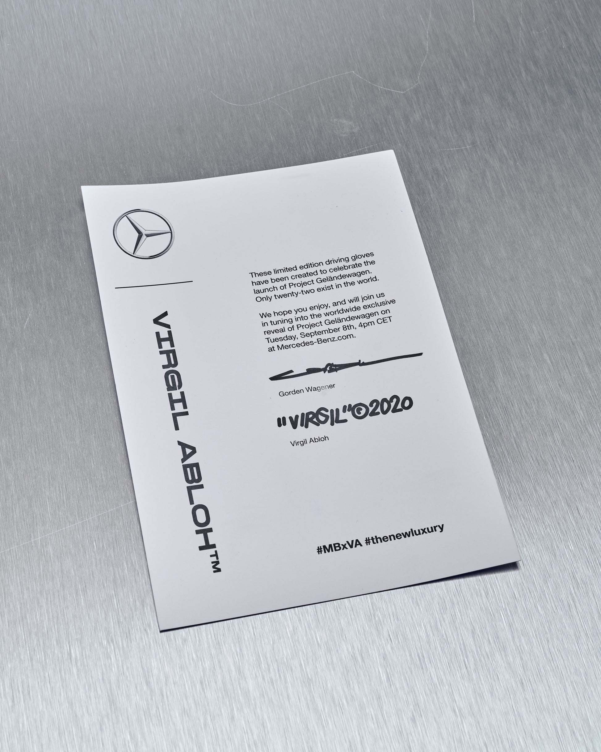 A card on a metallic surface features Mercedes-Benz and Virgil Abloh branding, announcing limited edition driving gloves. Hashtags and signatures are included.