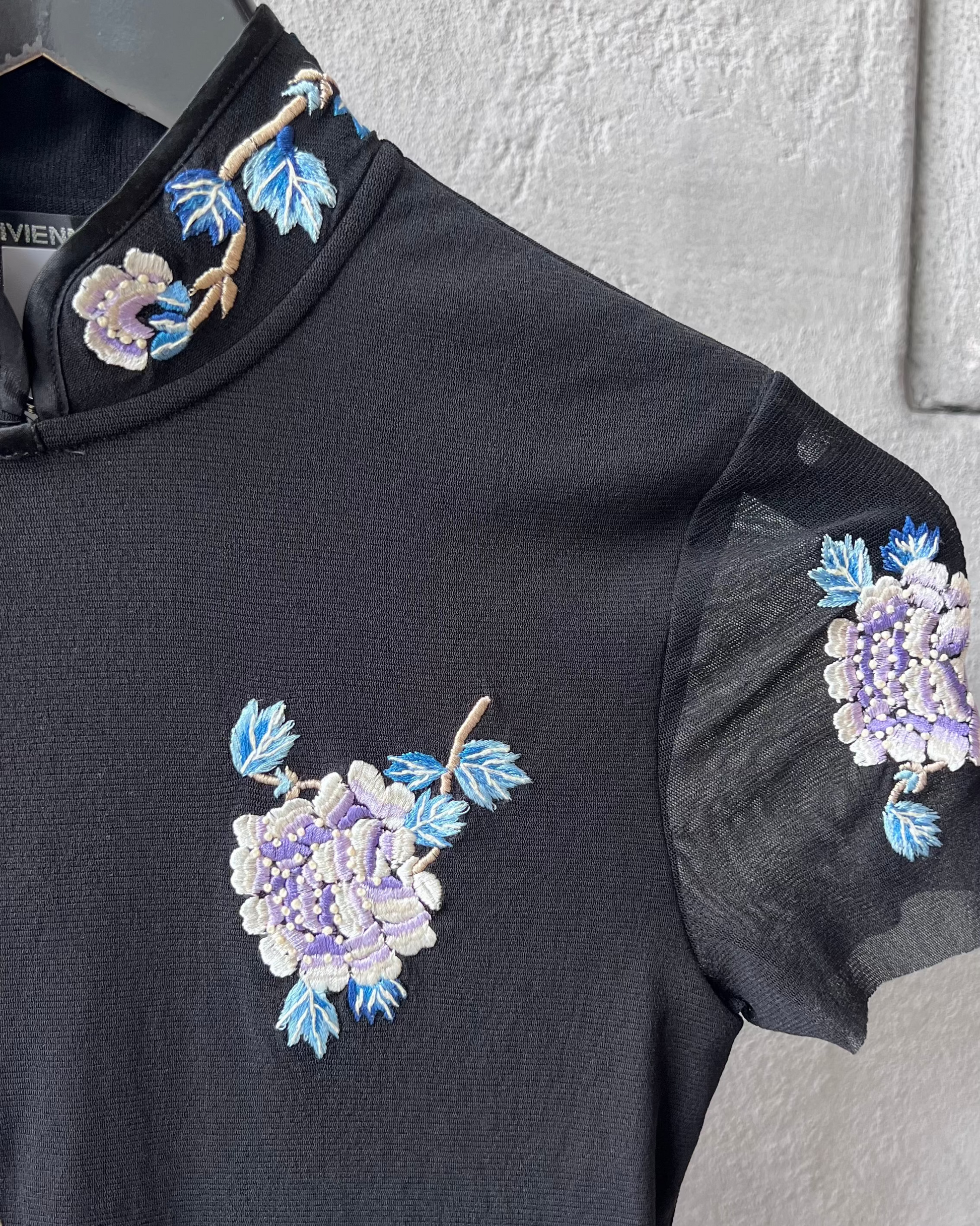 Black sleeveless Vivienne Tam top with floral embroidery on a gray background