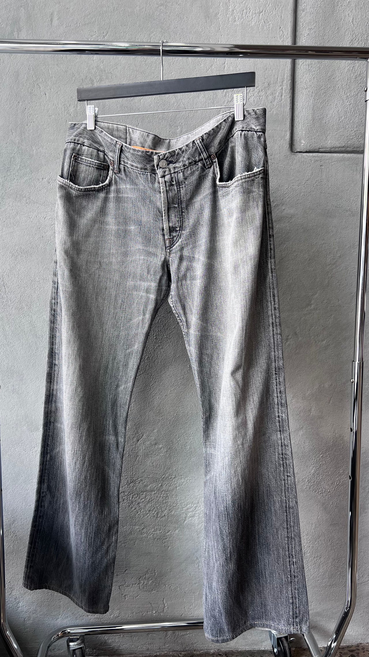 Gray Y-3 jeans with a brand logo on a textured gray background