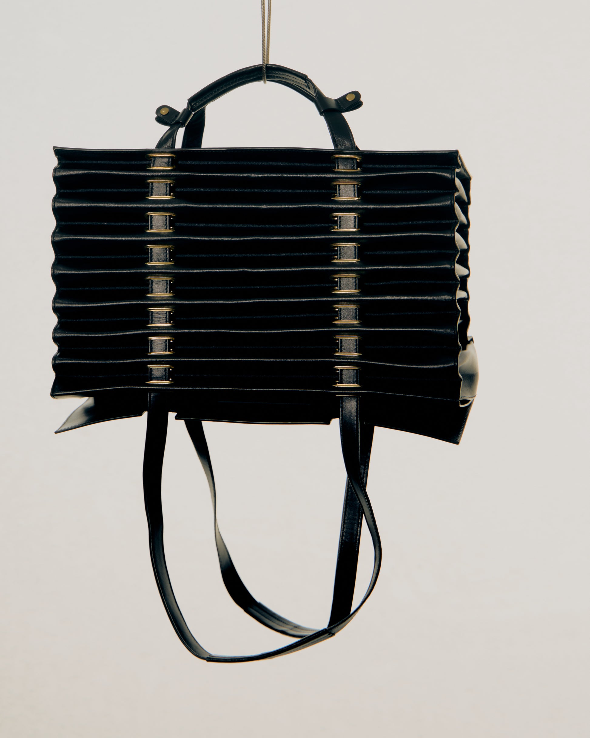 Black pleated Y/Project handbag on a light gray background
