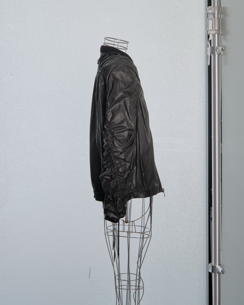Black Y/Project leather jacket on a wire mannequin against a light gray background
