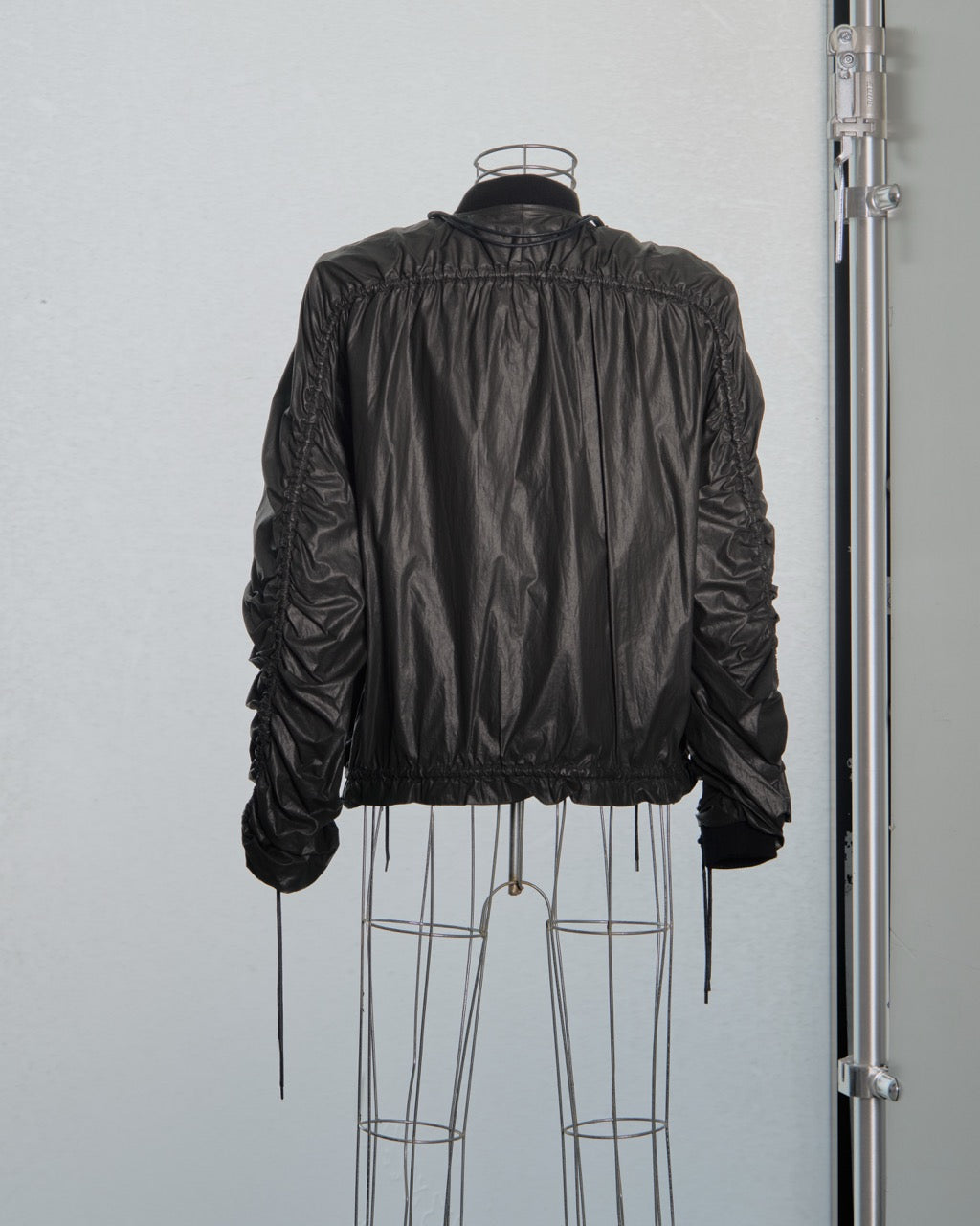 Black Y/Project jacket on a mannequin against a plain background
