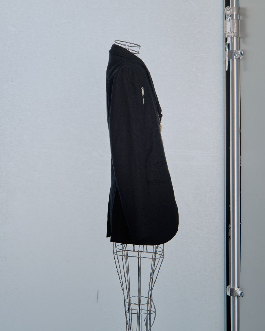 Black Yohji Yamamoto blazer on a wire mannequin against a light gray background