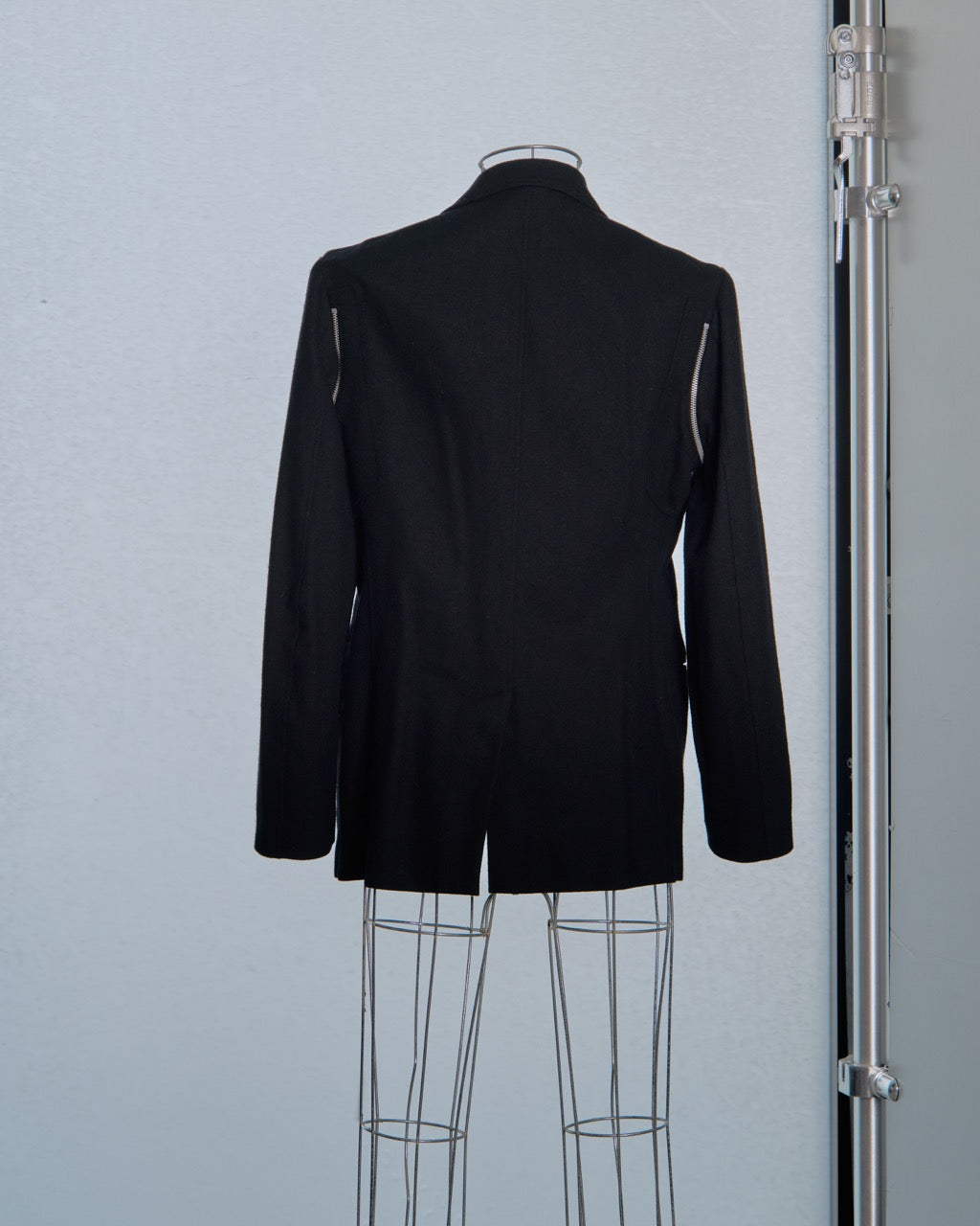 Black Yohji Yamamoto blazer on a mannequin against a light gray background