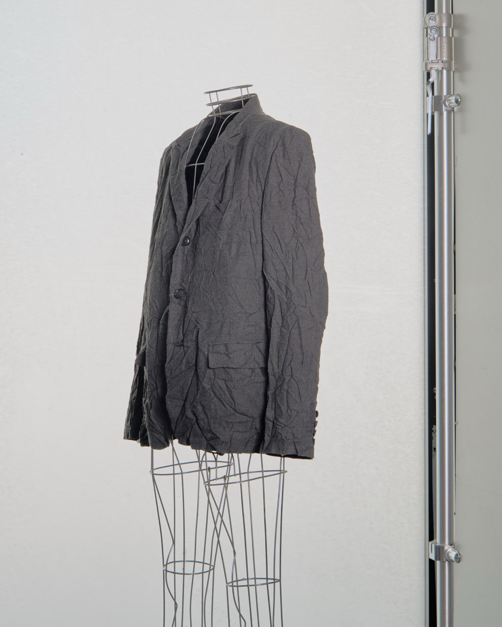 Gray Yohji Yamamoto blazer on a mannequin against a white background