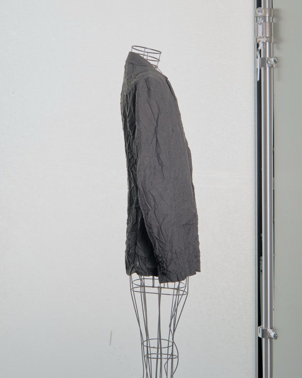 Dark gray jacket Yohji Yamamoto on a wire mannequin against a white background