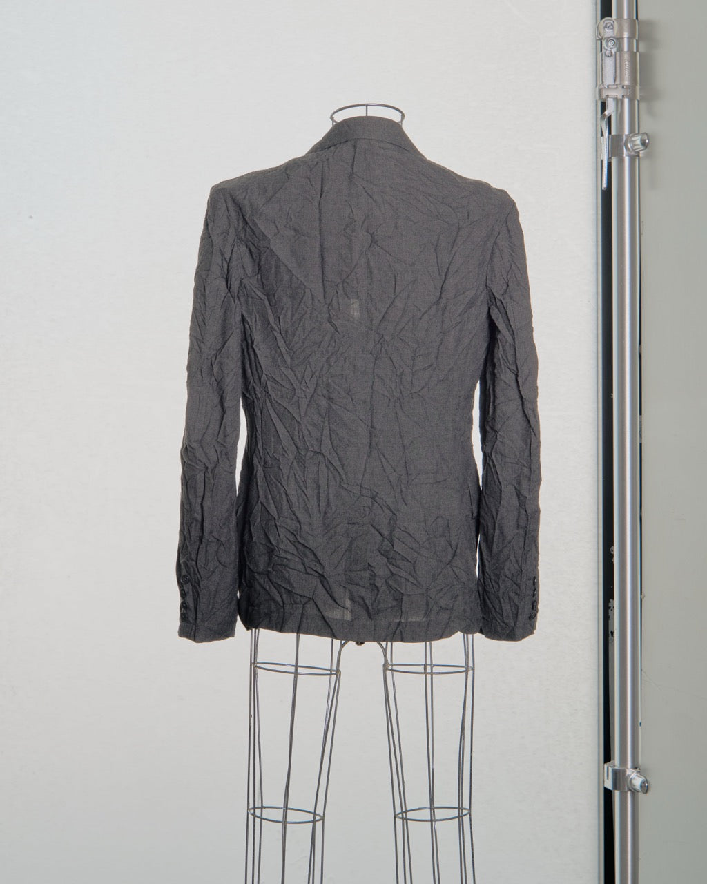 Gray Yohji Yamamoto textured jacket on a mannequin against a white background