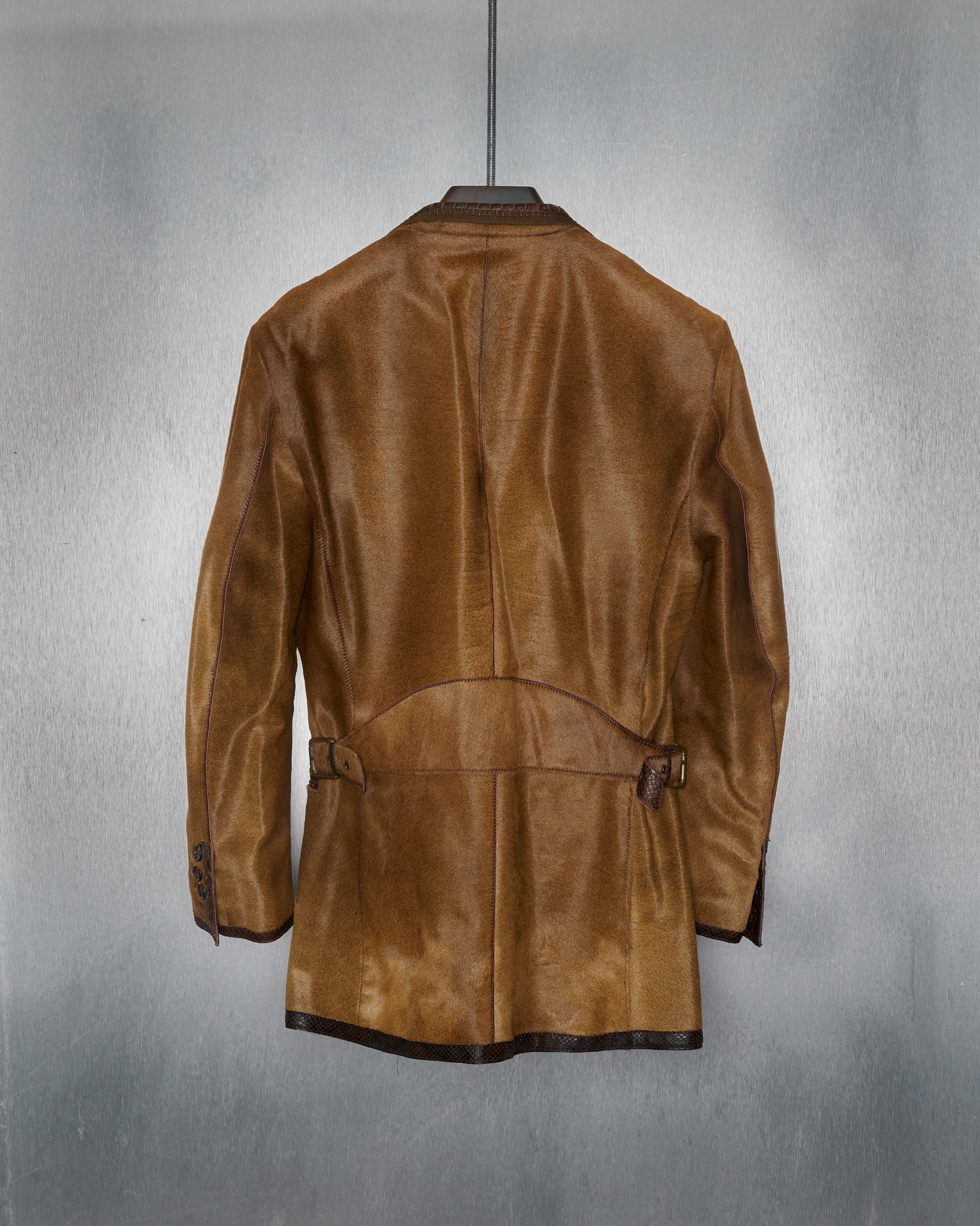 Back of a brown leather Roberto Cavalli jacket with python skin lapels and trimming, featuring a two-button blazer design, tanned python skin patch on the chest, and multiple pockets.