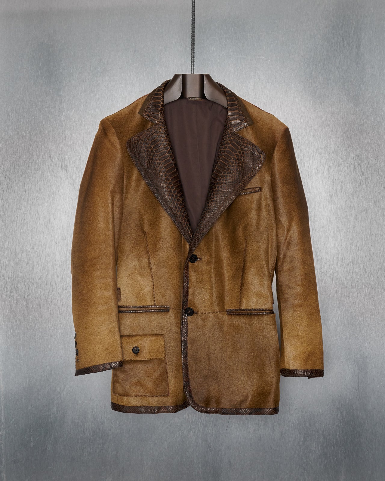 A brown leather Roberto Cavalli jacket with python skin lapels and trimming, featuring a two-button blazer design, tanned python skin patch on the chest, and multiple pockets.