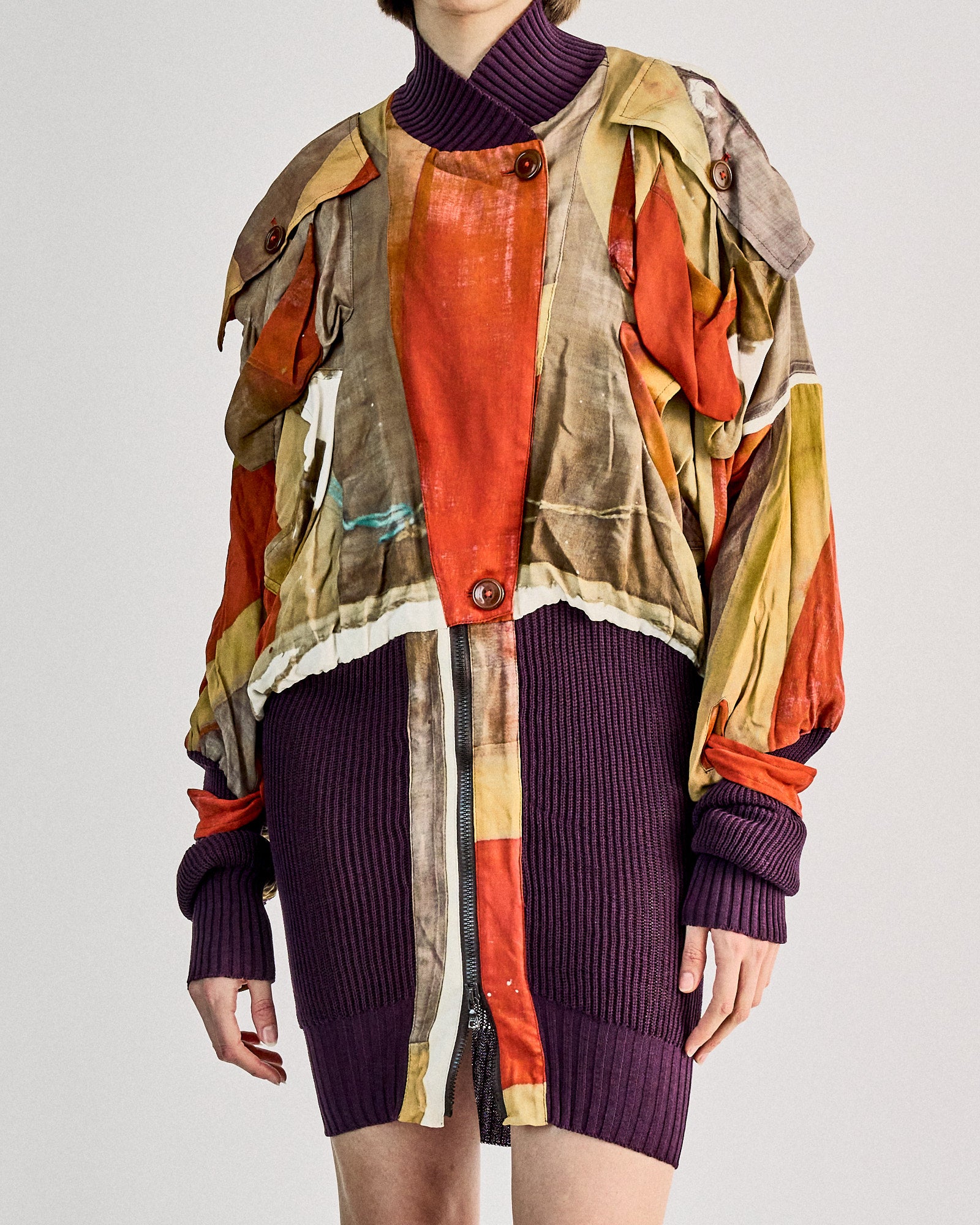 A person wears a colourful, abstract-patterned Vivienne Westwood jacket.